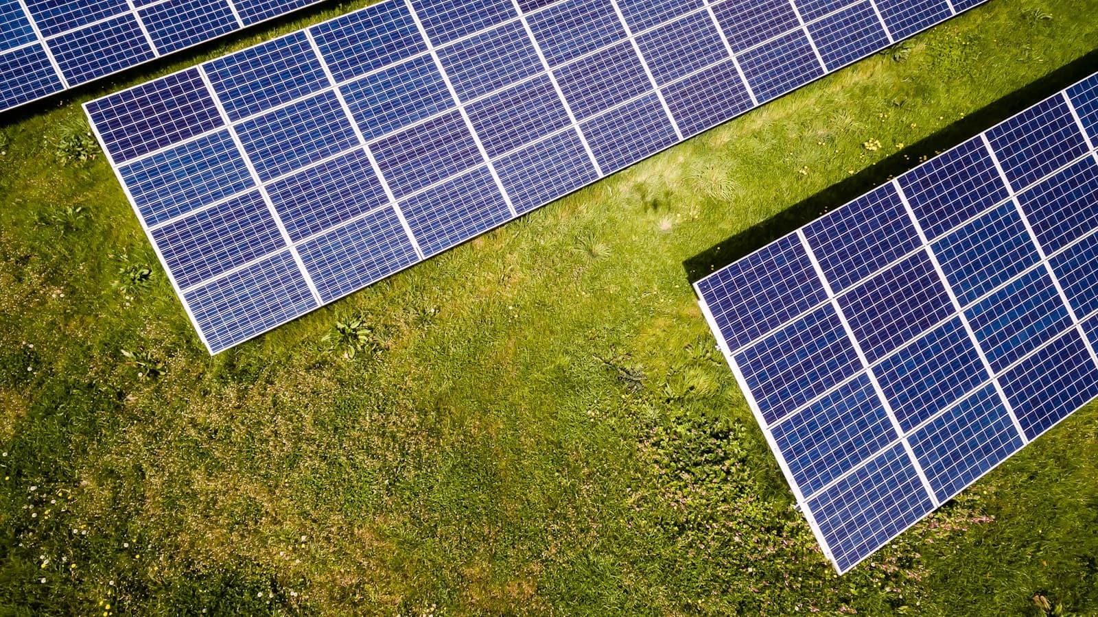 Workers installing solar panels on industrial factory rooftop