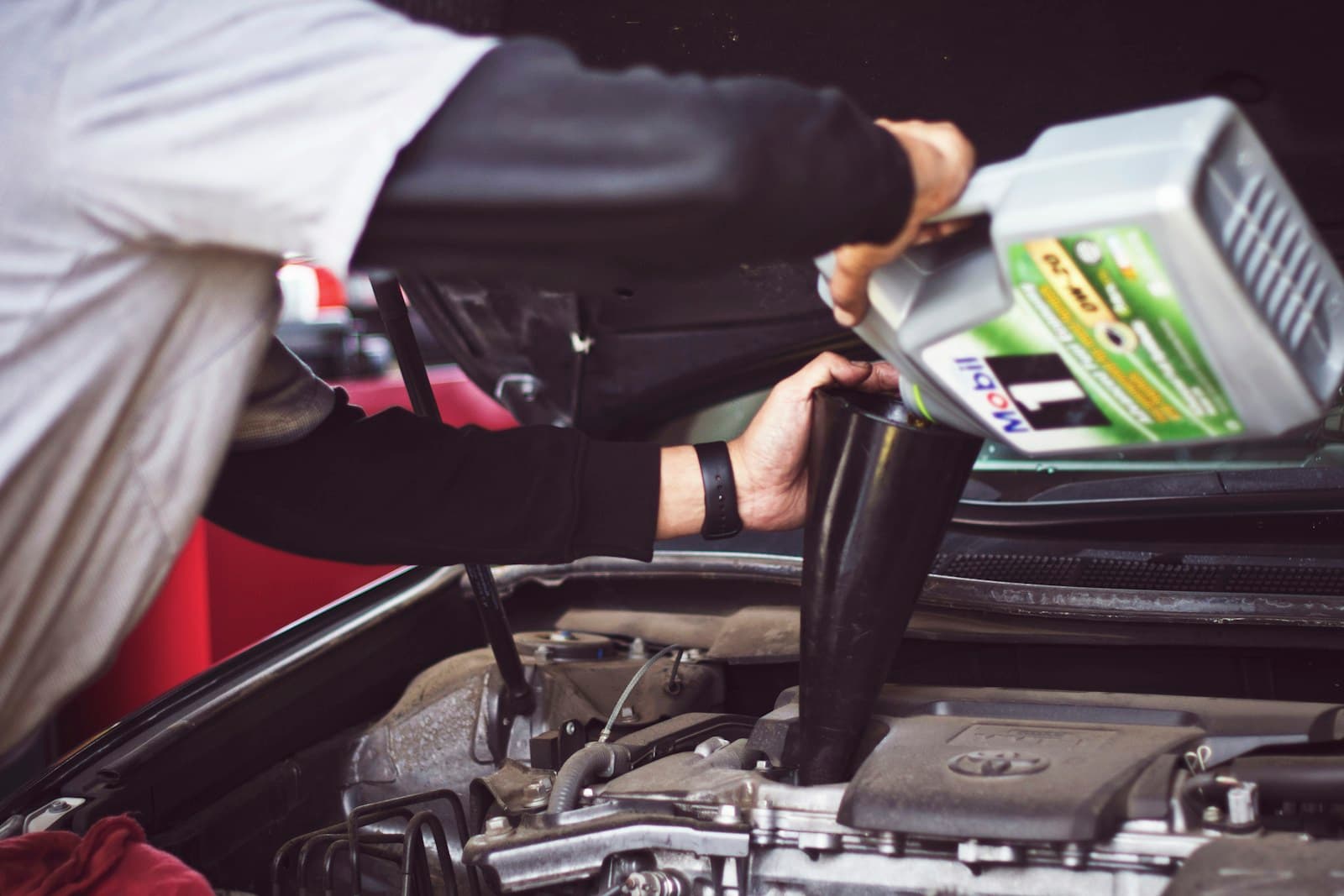 Mechanic performing engine oil change on industrial equipment