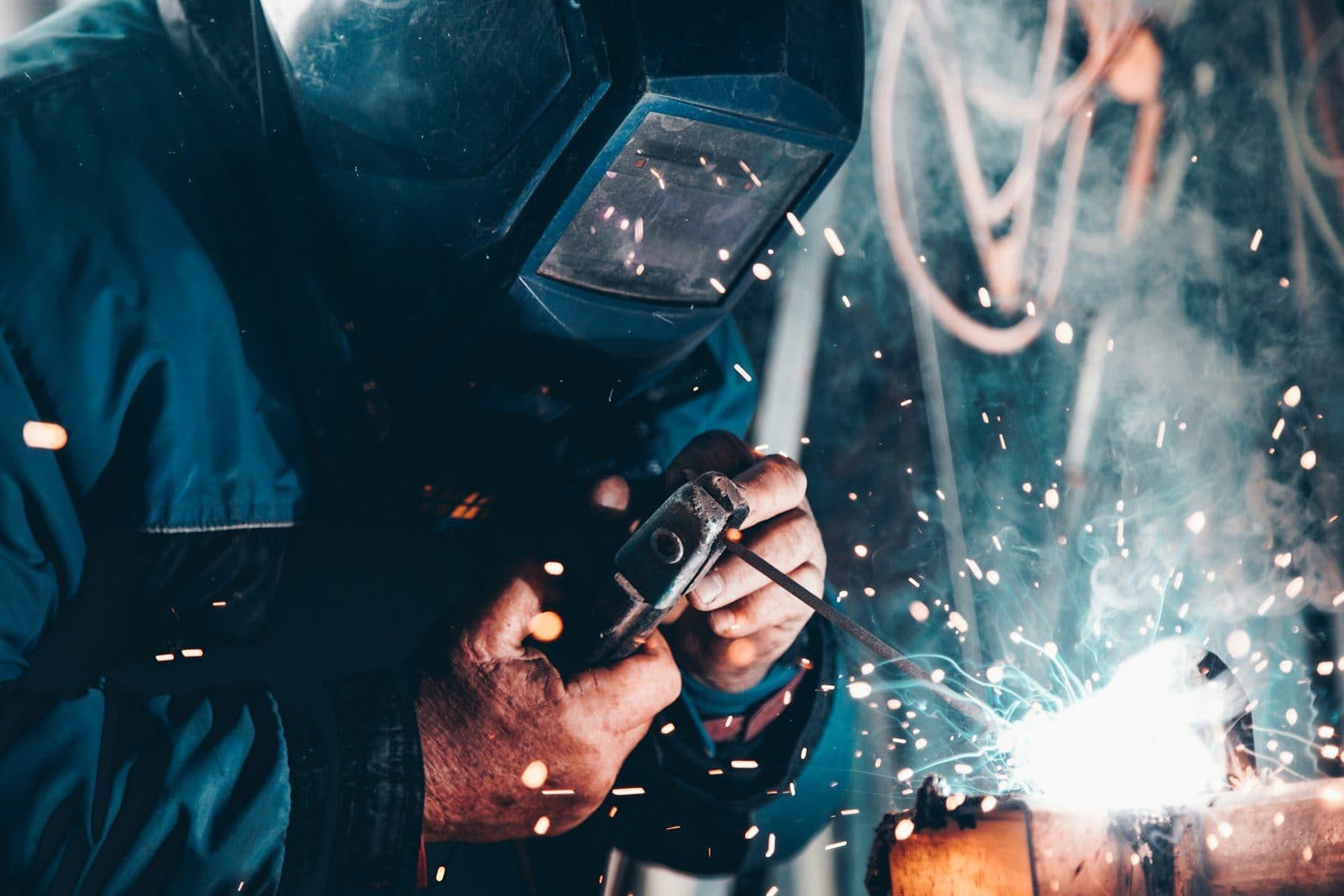 Arc welding sparks flying in an industrial workshop — fire blanket protection required